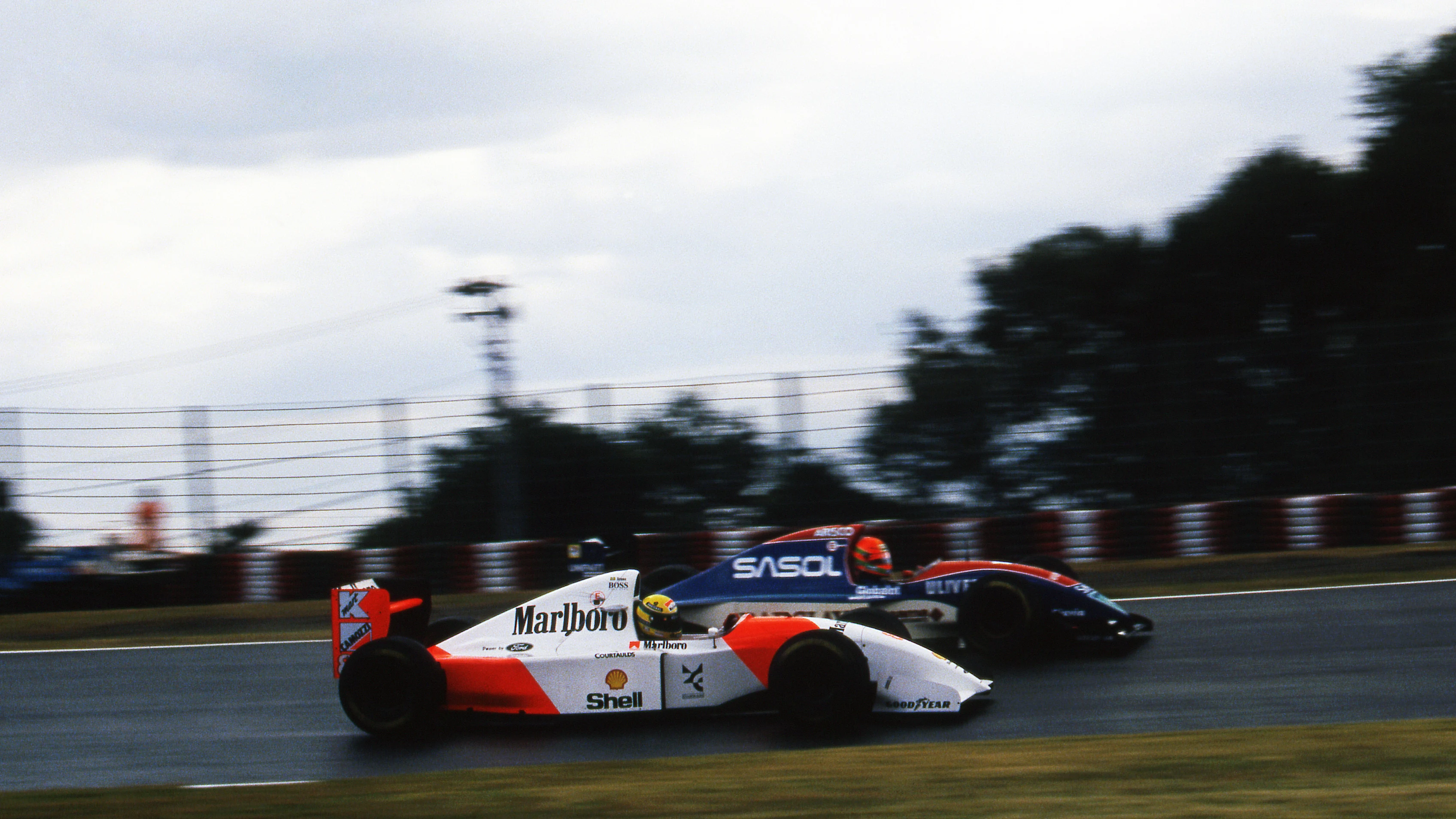 Ayrton Senna (BRA) McLaren Ford MP4/8 passes Eddie Irvine (GBR) Jordan Hart J193 on the way to the