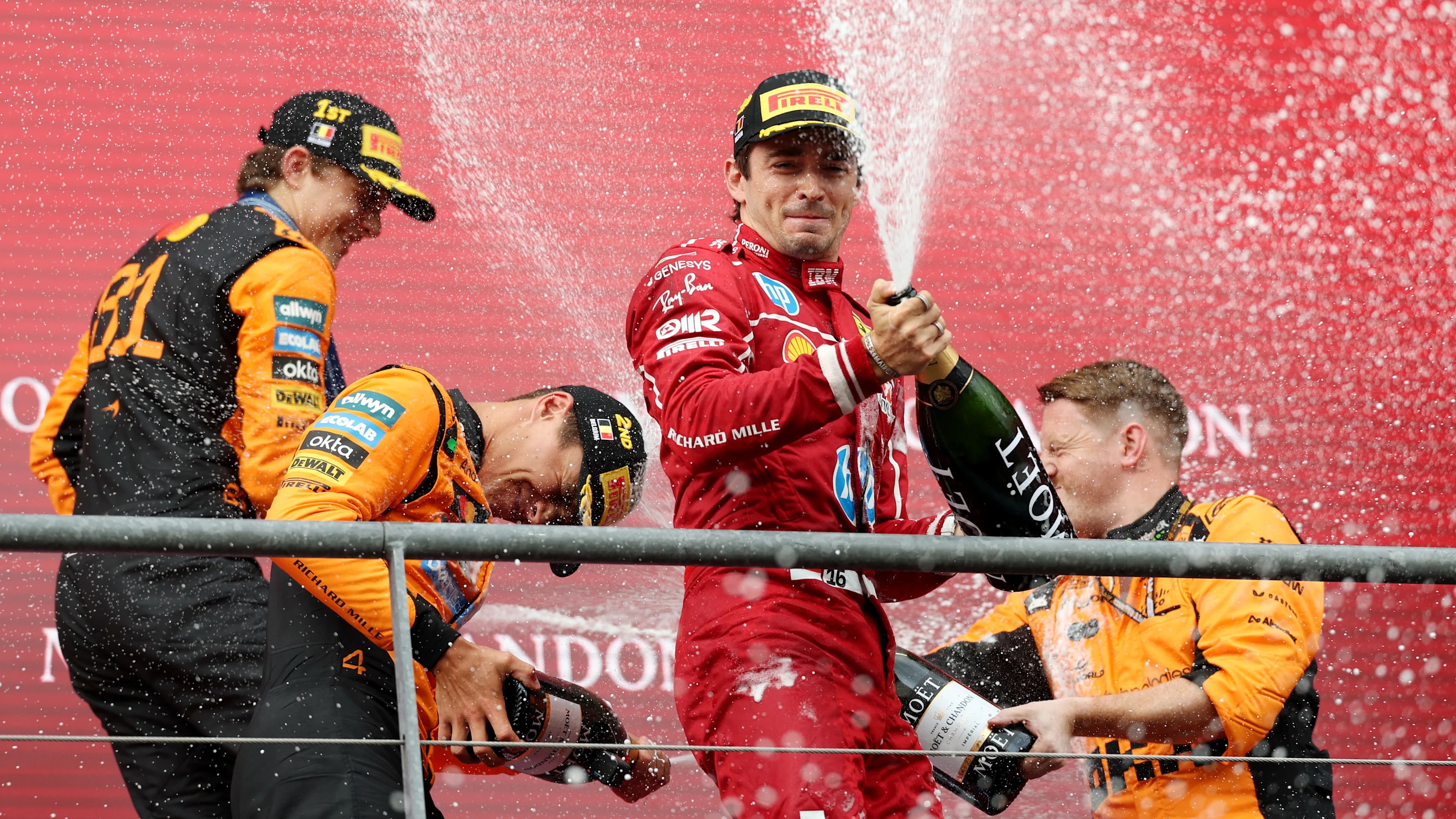SPA, BELGIUM - JULY 27: Race winner Oscar Piastri of Australia and McLaren Second placed Lando Norris of Great Britain and McLaren Third placed Charles Leclerc of Monaco and Scuderia Ferrari and the McLaren trophy delegate celebrate with Champagne on the podium during the F1 Grand Prix of Belgium at Circuit de Spa-Francorchamps on July 27, 2025 in Spa, Belgium. (Photo by Ryan Pierse/Getty Images)