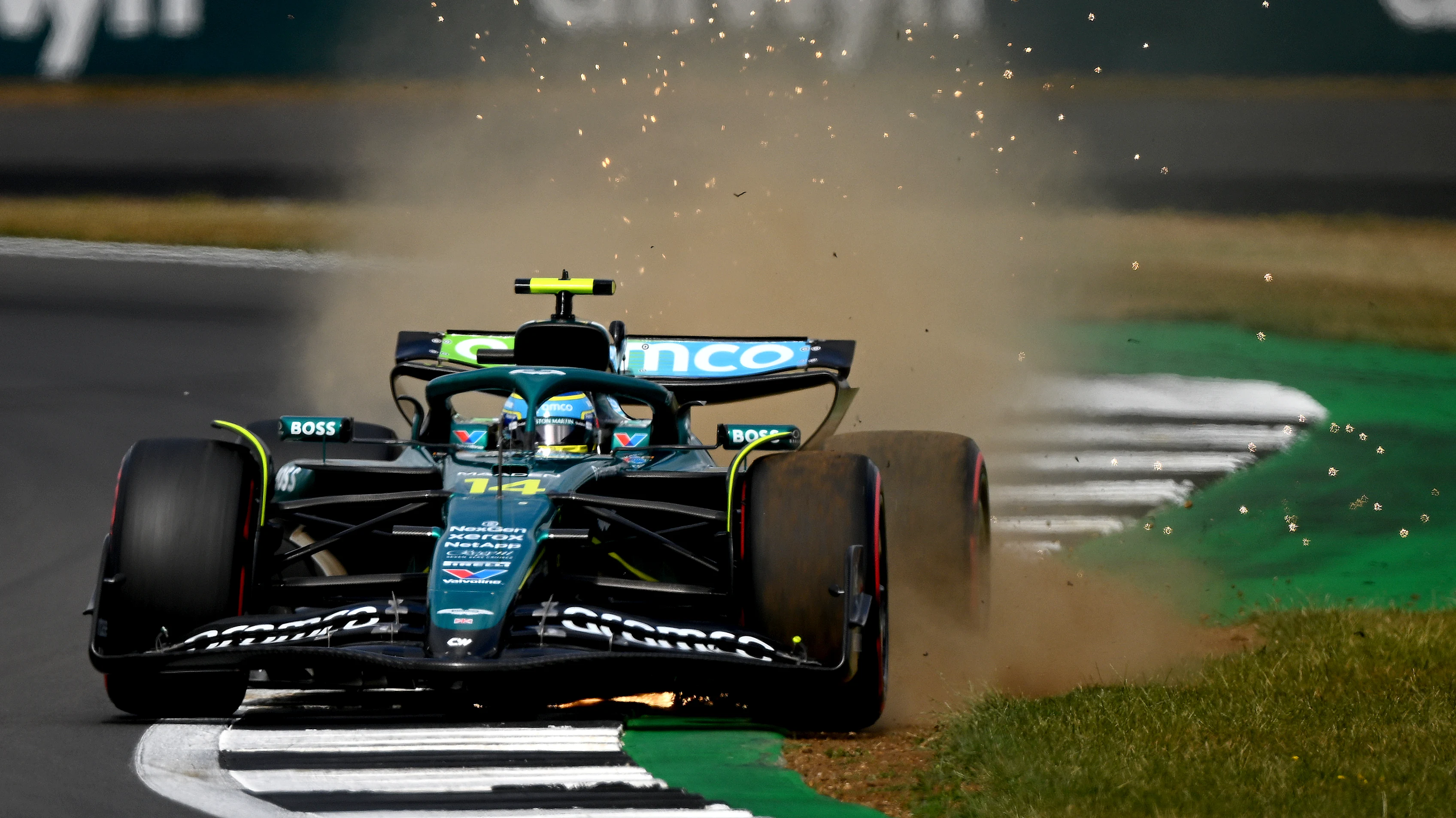 NORTHAMPTON, ENGLAND - JULY 05: Sparks and mud fly behind Fernando Alonso of Spain driving the (14)