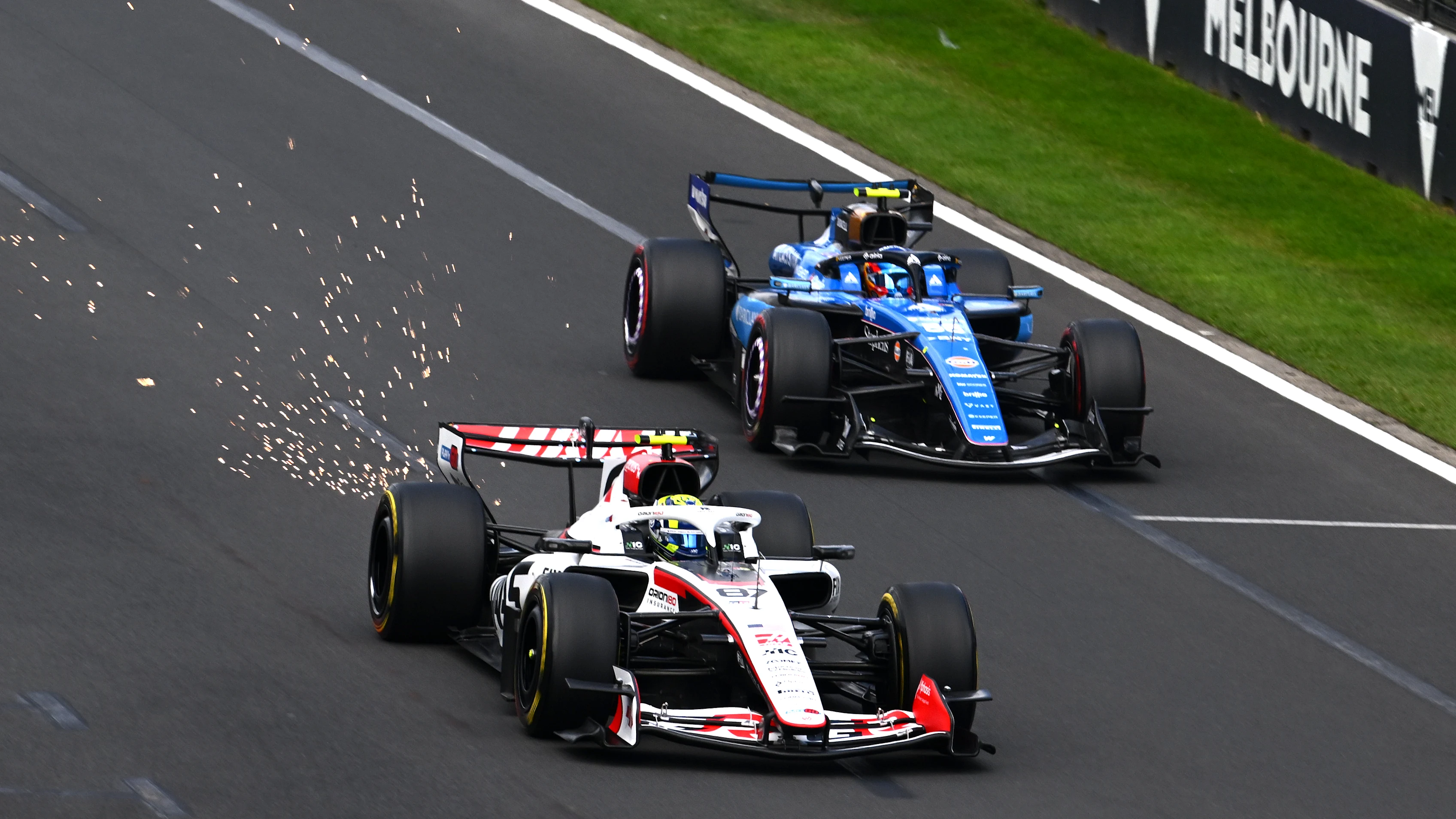 MELBOURNE, AUSTRALIA - MARCH 08: Sparks fly behind Oliver Bearman of Great Britain driving the (87) Haas F1 VF-26 Ferrari as he leads Carlos Sainz of Spain driving the (55) Williams FW48 Mercedes on track during the F1 Grand Prix of Australia at Albert Park Grand Prix Circuit on March 08, 2026 in Melbourne, Australia. (Photo by Mark Sutton - Formula 1/Formula 1 via Getty Images)