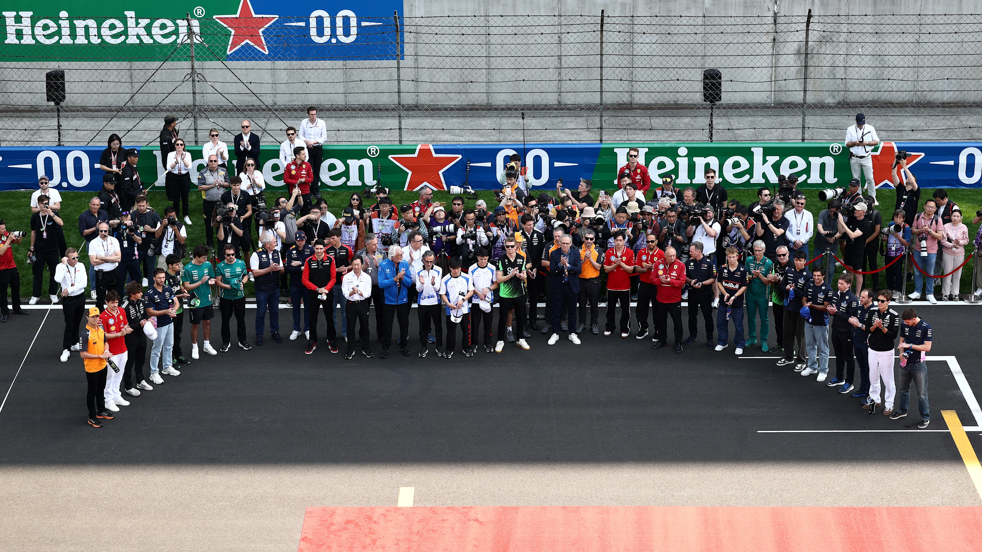 SHANGHAI, CHINA - MARCH 23: Drivers and team personnel gather in tribute to the late Eddie Jordan