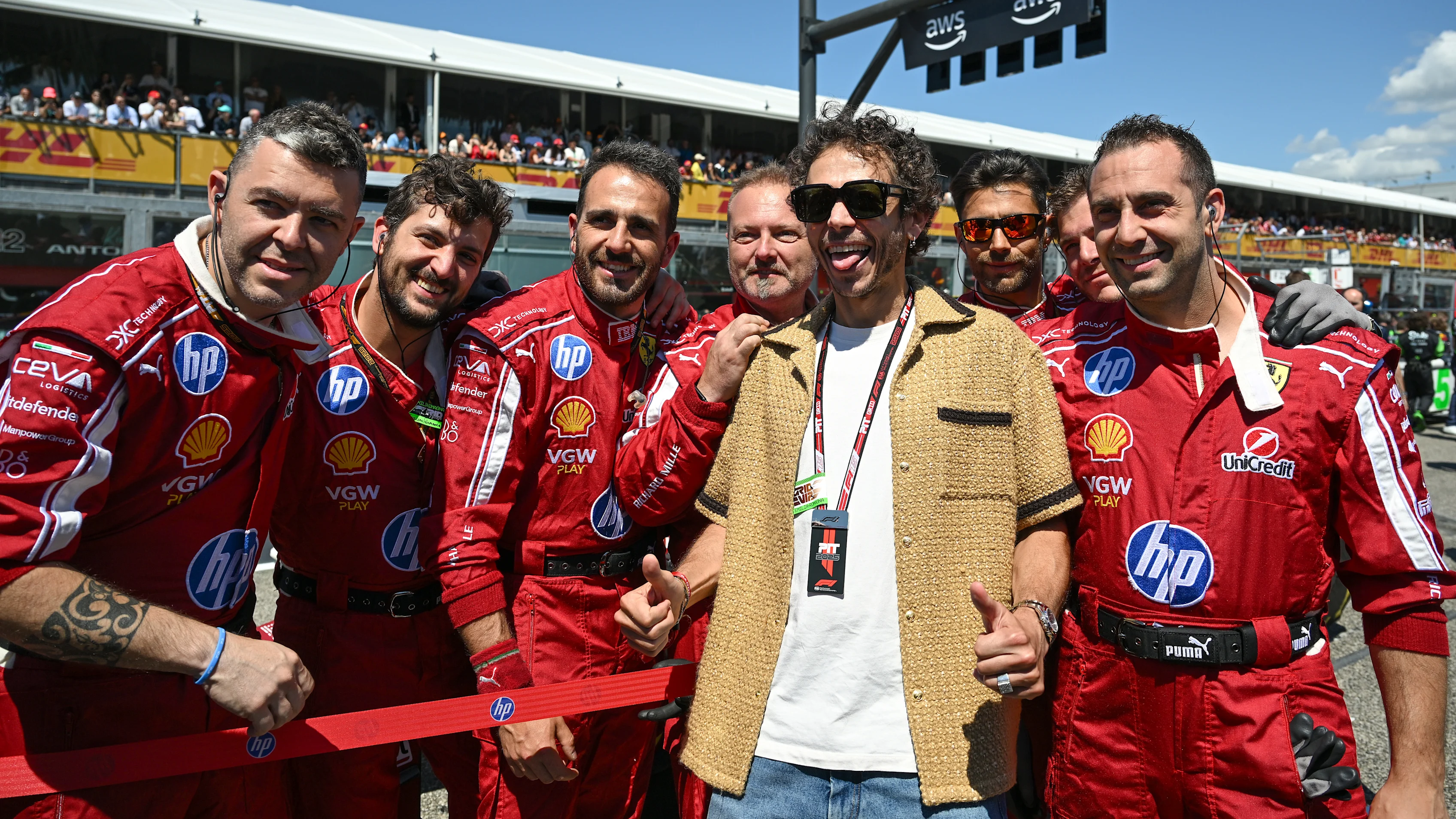 Valentino Rossi poses for a photo with the Ferrari team on the grid