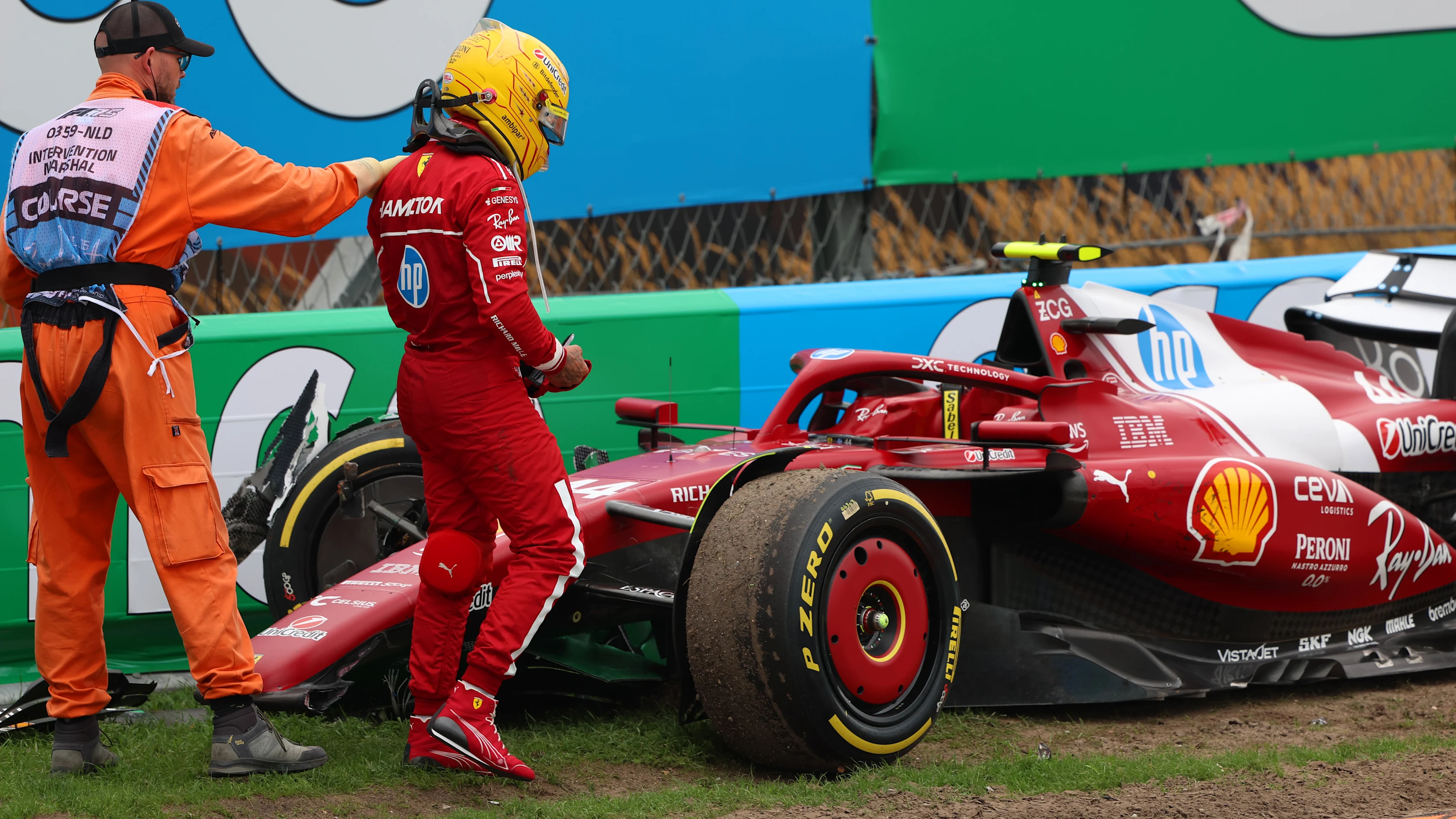 ZANDVOORT, NETHERLANDS - AUGUST 31: A marshal assists Lewis Hamilton of Great Britain and Scuderia Ferrari after a crash during the F1 Grand Prix of Netherlands at Circuit Zandvoort on August 31, 2025 in Zandvoort, Netherlands. (Photo by Andy Hone/LAT Images)