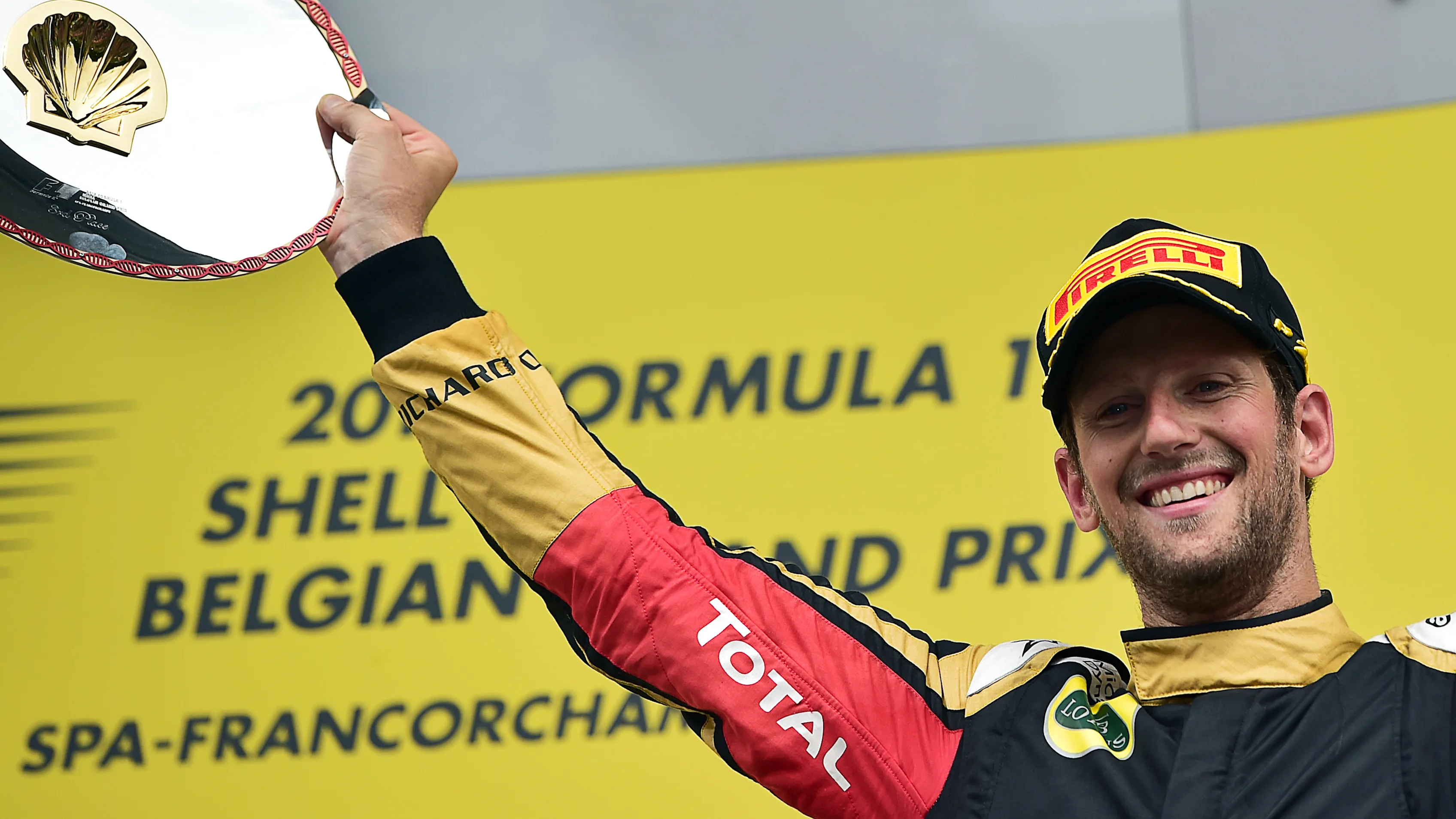 Third-placed Lotus F1 Team's French driver Romain Grosjean celebrates with his trophy on the podium