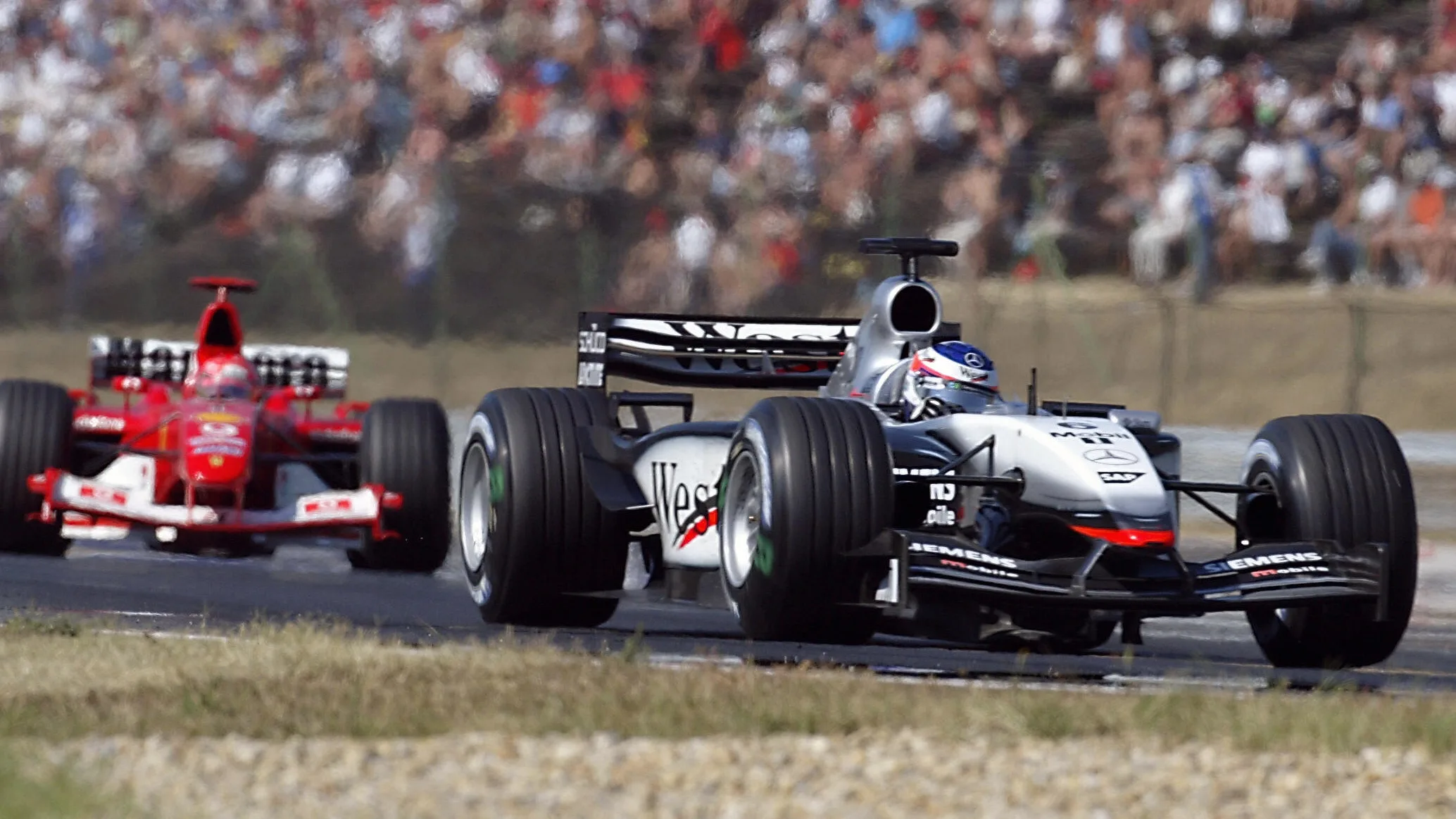 McLaren-Mercedes driver Kimi Raikkonen steers his car ahead of German BMW-Williams driver Ralf