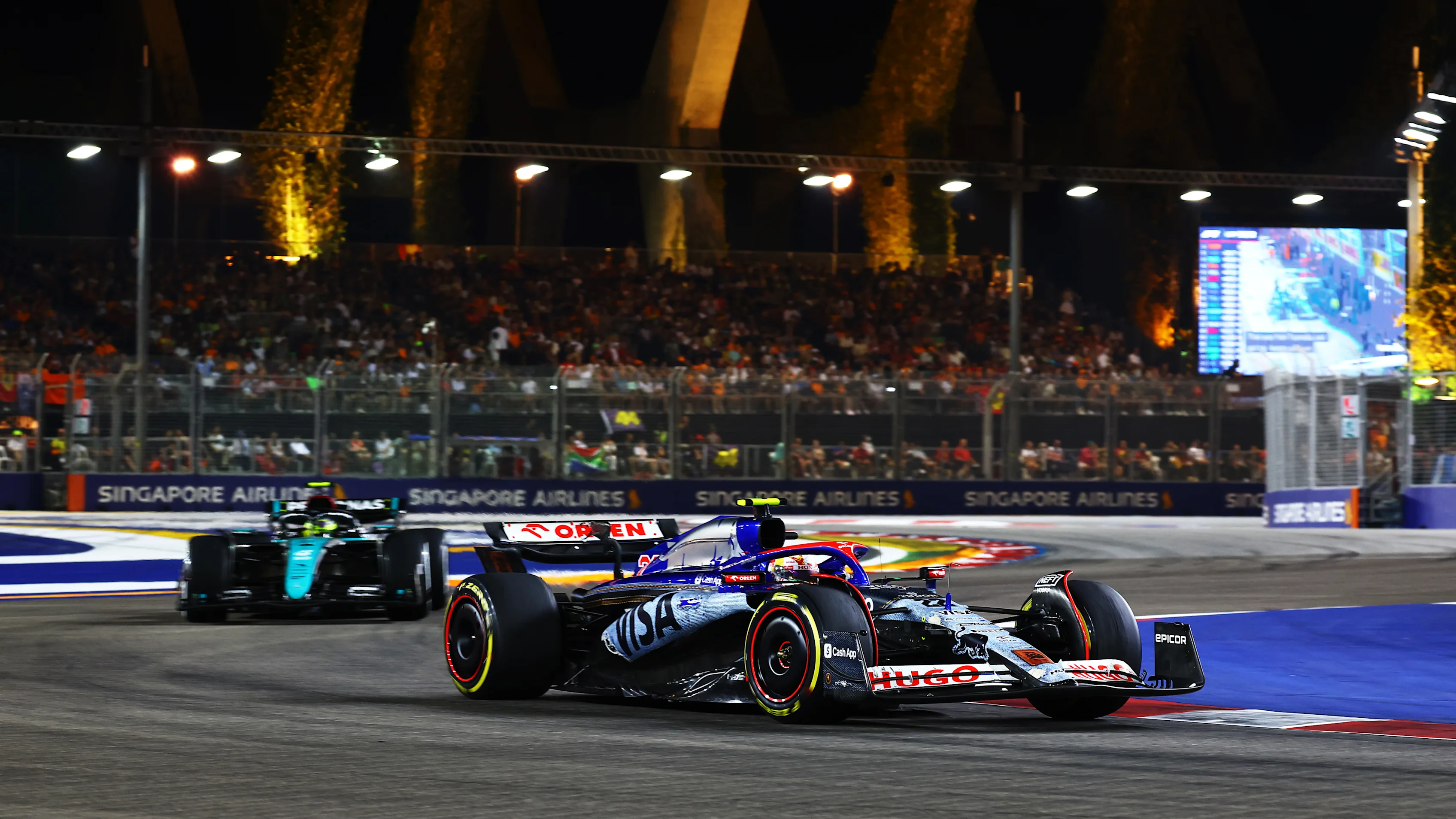 SINGAPORE, SINGAPORE - SEPTEMBER 22: Yuki Tsunoda of Japan driving the (22) Visa Cash App RB VCARB 01 leads Lewis Hamilton of Great Britain driving the (44) Mercedes AMG Petronas F1 Team W15 on track during the F1 Grand Prix of Singapore at Marina Bay Street Circuit on September 22, 2024 in Singapore, Singapore. (Photo by Mark Thompson/Getty Images)