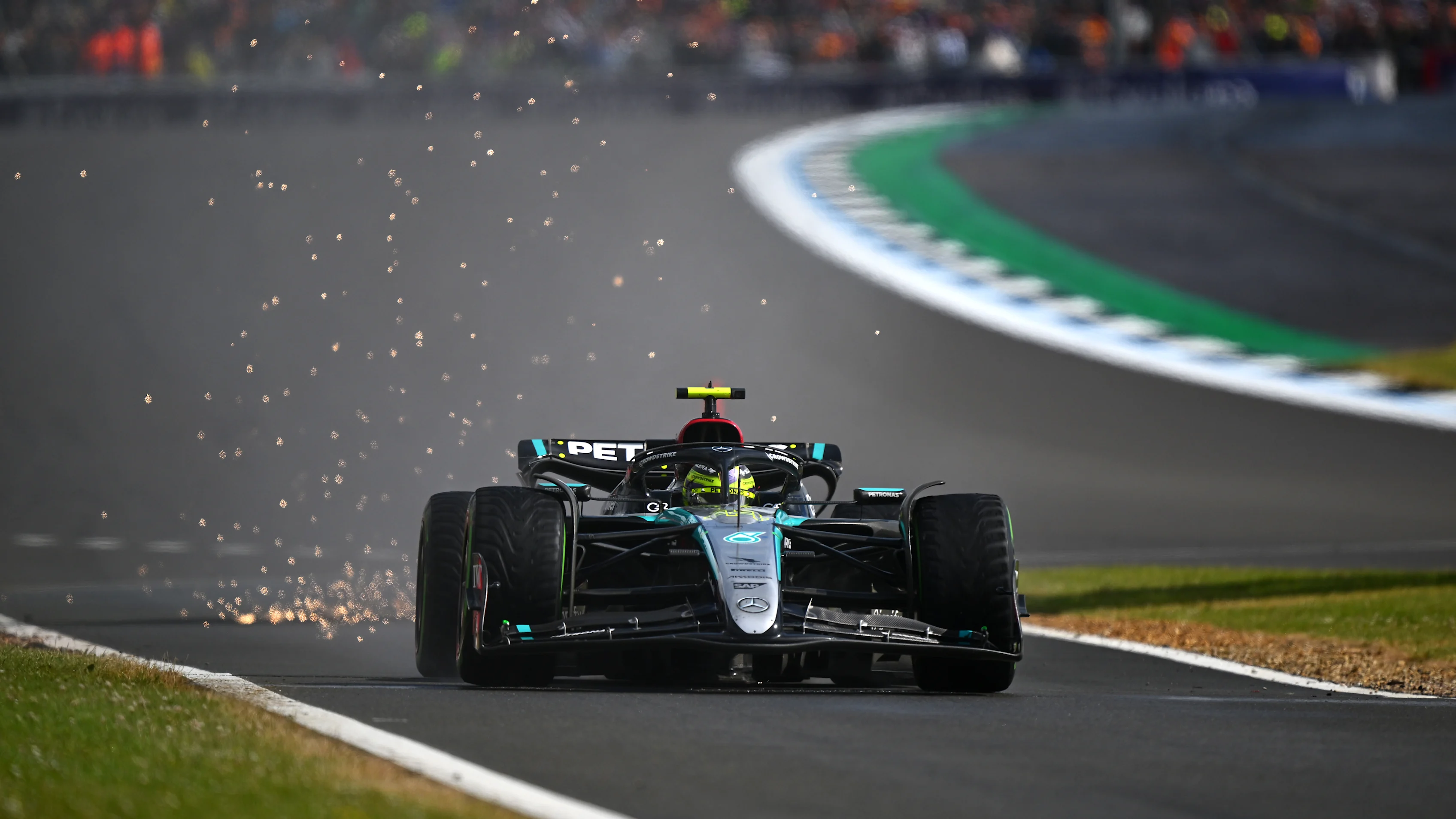 NORTHAMPTON, ENGLAND - JULY 07: Sparks fly behind Lewis Hamilton of Great Britain driving the (44)