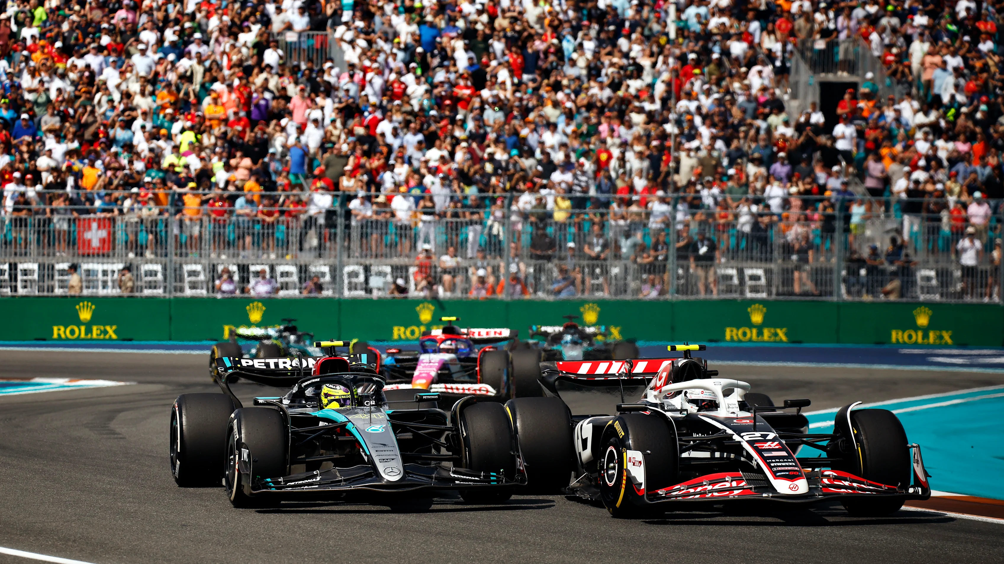 MIAMI, FLORIDA - MAY 05: Nico Hulkenberg of Germany driving the (27) Haas F1 VF-24 Ferrari and Lewis Hamilton of Great Britain driving the (44) Mercedes AMG Petronas F1 Team W15 battle for position on track during the F1 Grand Prix of Miami at Miami International Autodrome on May 05, 2024 in Miami, Florida. (Photo by Chris Graythen/Getty Images)
