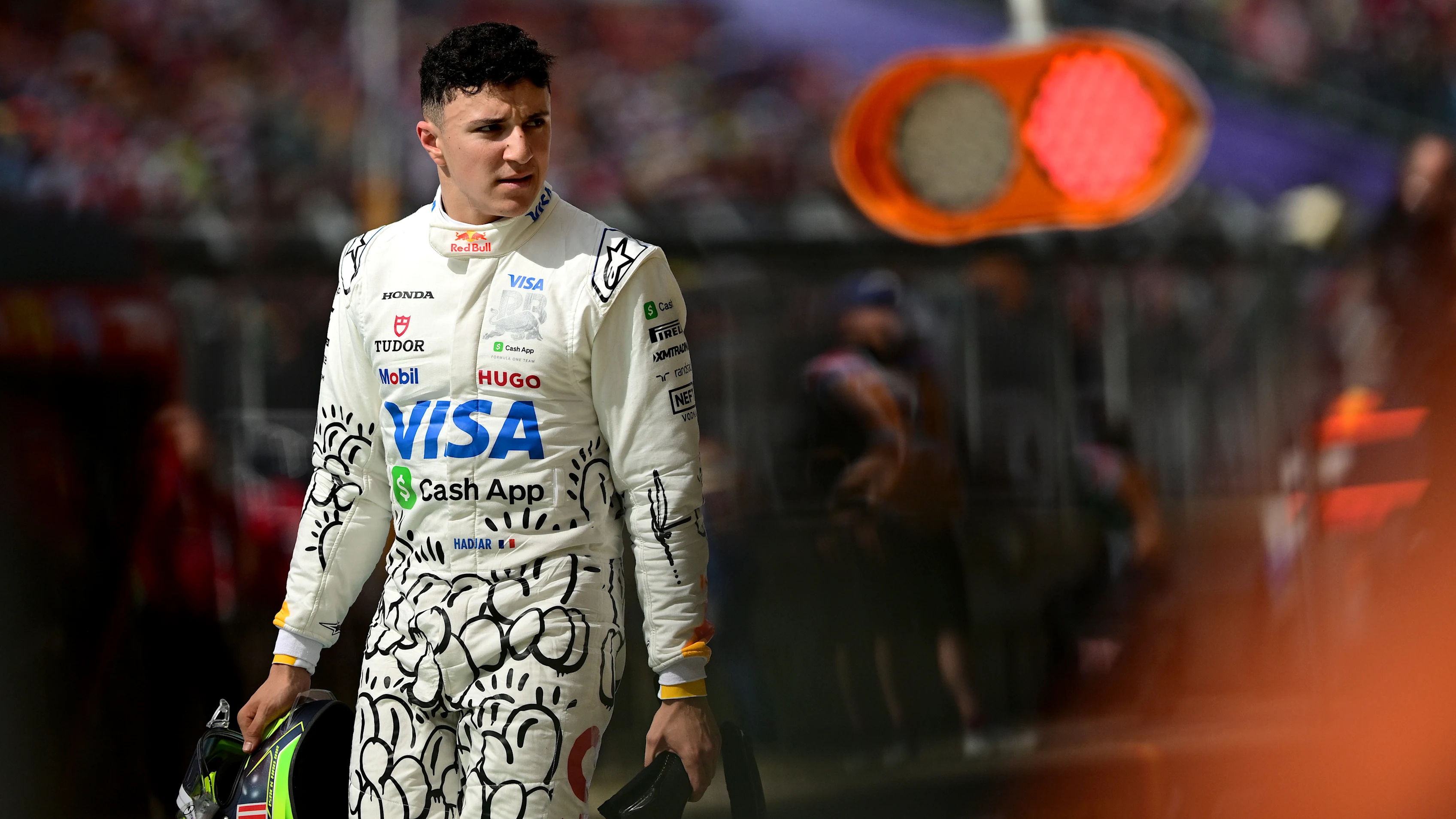 NORTHAMPTON, ENGLAND - JULY 05: Thirteenth placed qualifier Isack Hadjar of France and Visa Cash App Racing Bulls walks in the Pitlane during qualifying ahead of the F1 Grand Prix of Great Britain at Silverstone Circuit on July 05, 2025 in Northampton, England. (Photo by Mario Renzi - Formula 1/Formula 1 via Getty Images)