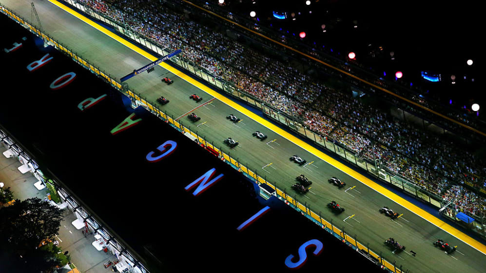 SINGAPORE - SEPTEMBER 20: Sebastian Vettel of Germany and Ferrari pulls away from the start ahead
